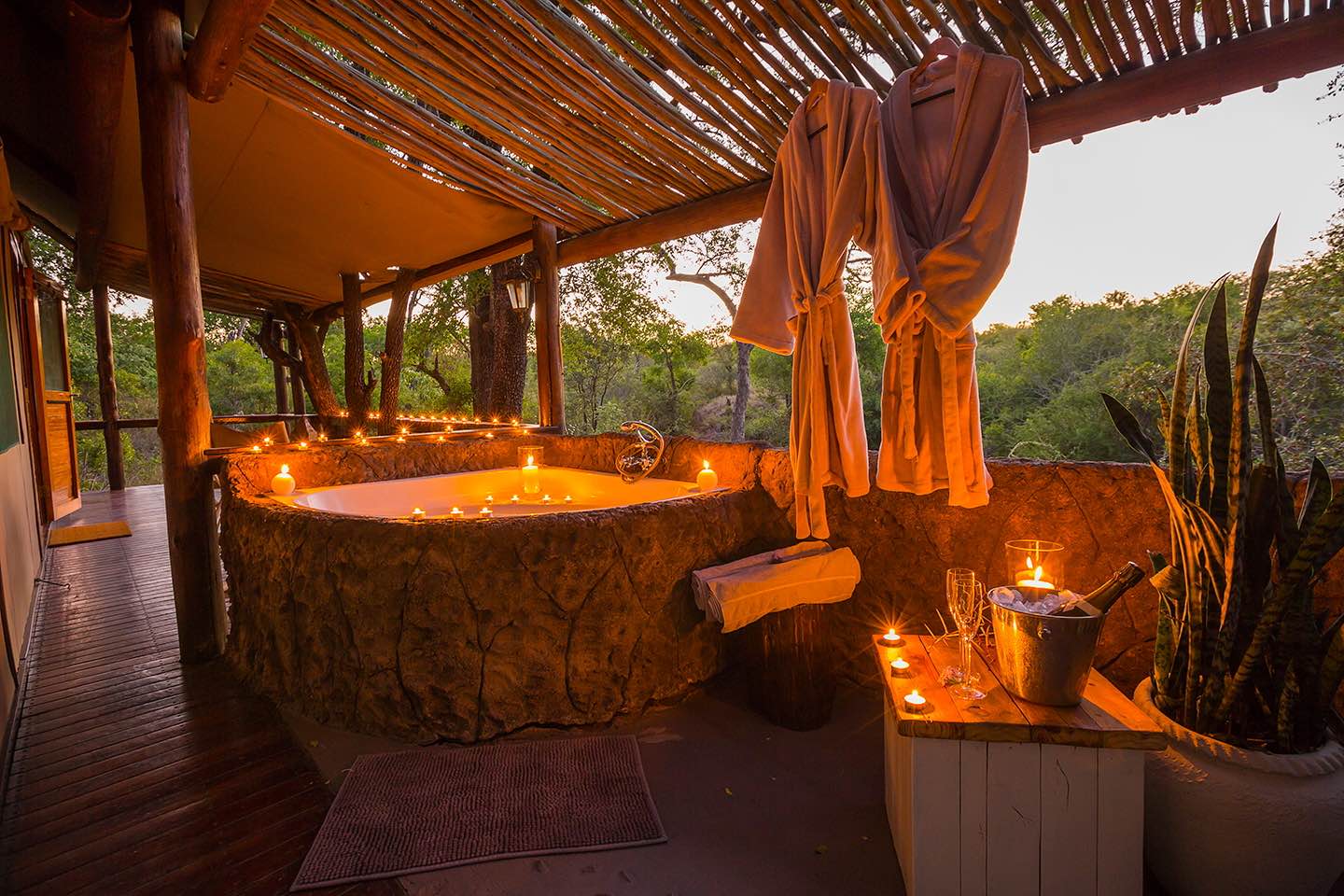 Unique featured bath tub with plenty of candles and a view of the bush at Chapungu Tented Camp