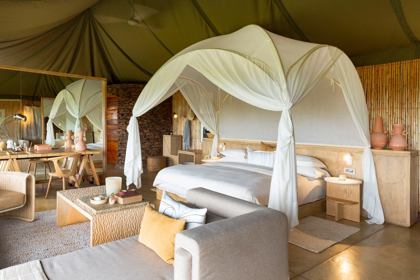 Tent interiors at Faru Faru with contemporary, clean-cut designs and a domed mosquito net enclosing the bed