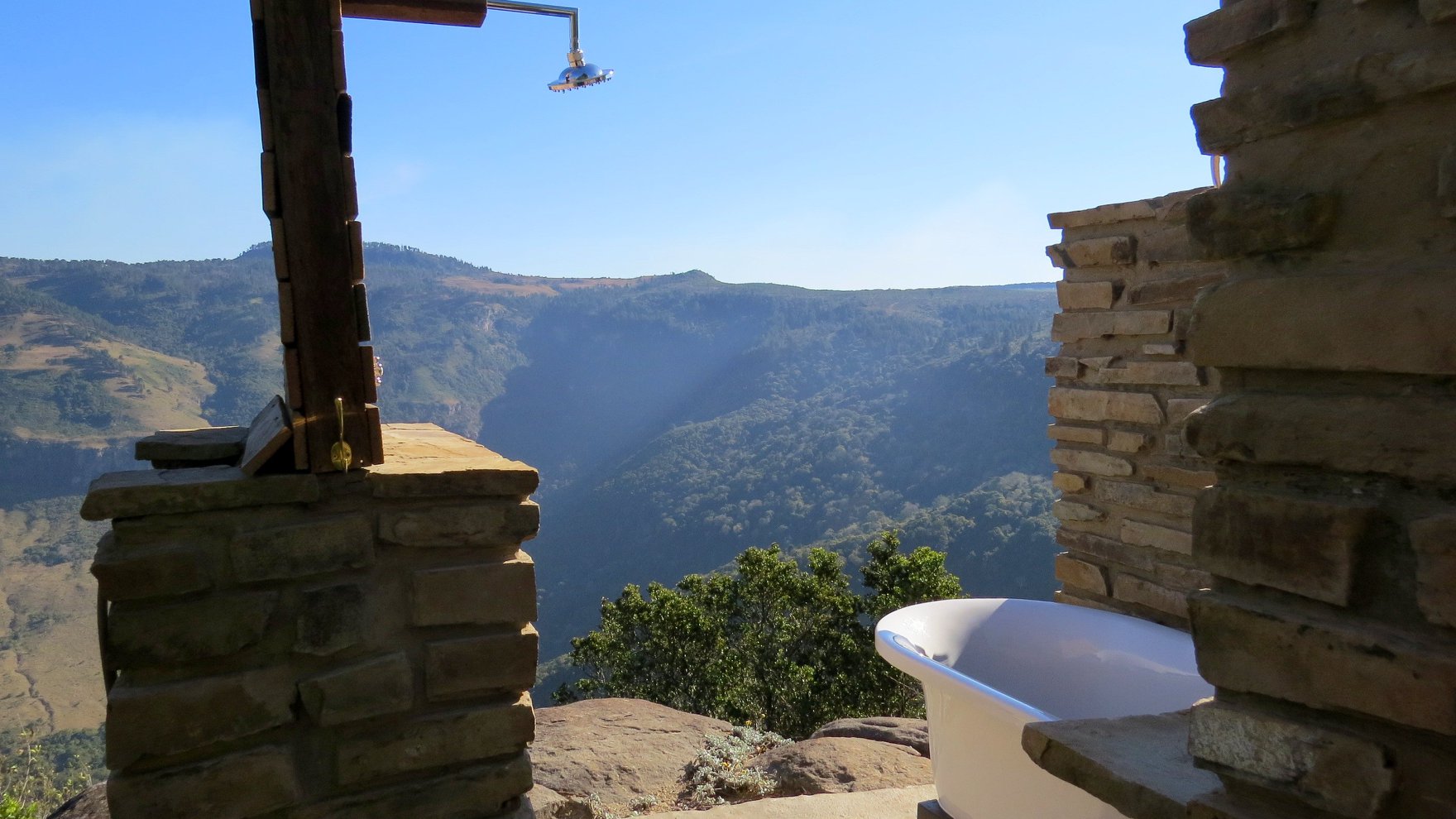 An outdoor bathroom with views of the Hogsback mountains and cliffs