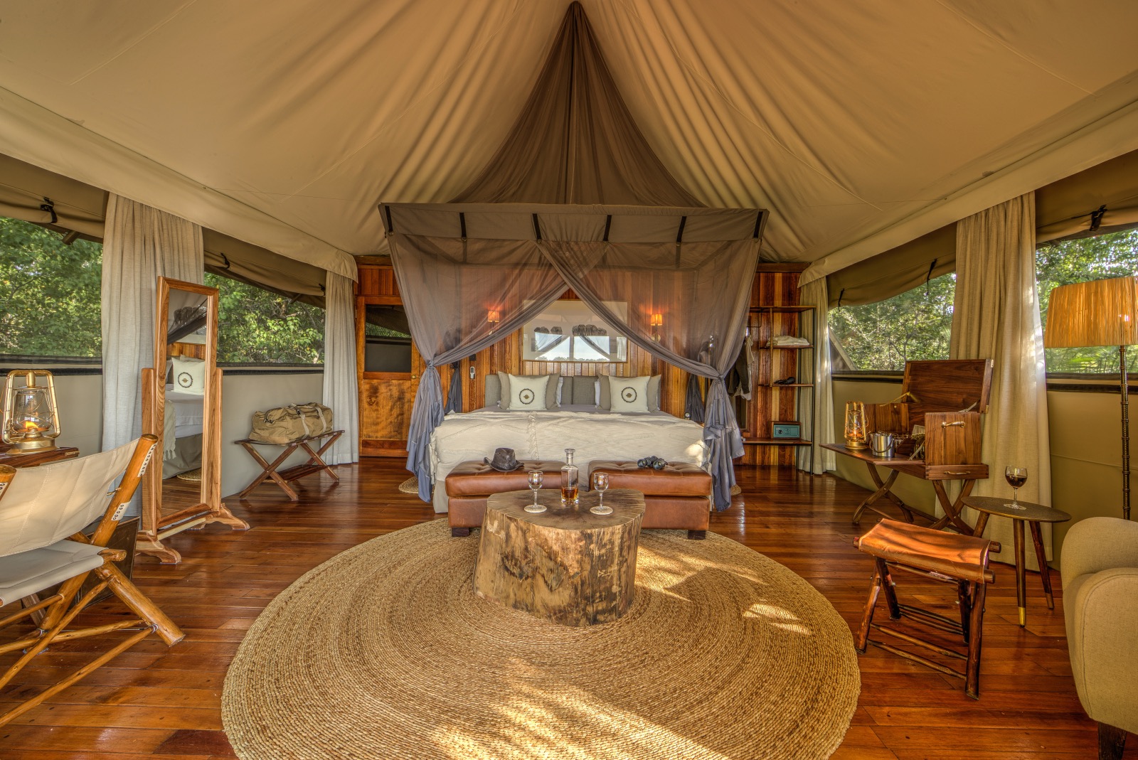 Elegant safari bedroom with canvas ceiling and wooden floors and a four-posted king-size bed in the middle